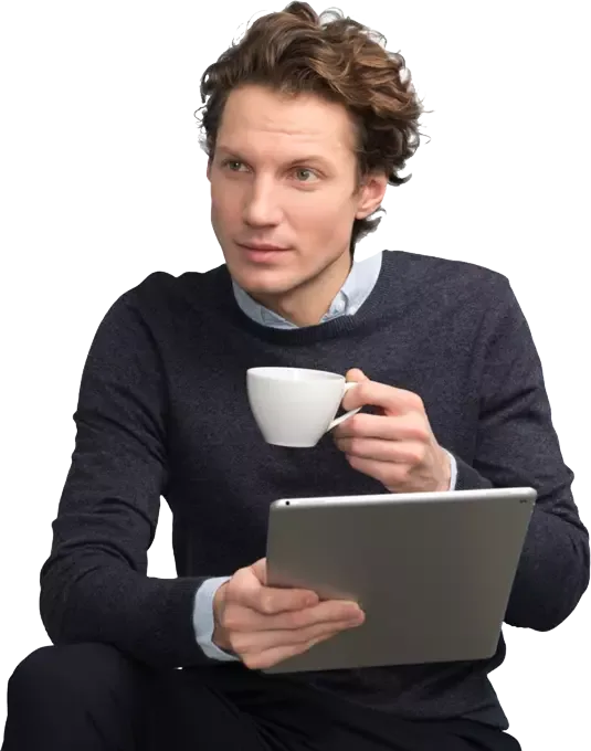 A man with a cup of coffee, holding a tablet