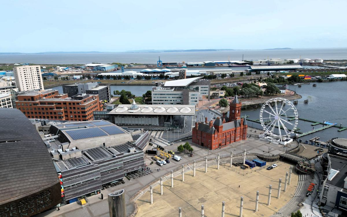 Aerial view of Cardiff Bay with the red-brick Pierhead Building, the Senedd, a Ferris wheel and Roald Dahl Plass