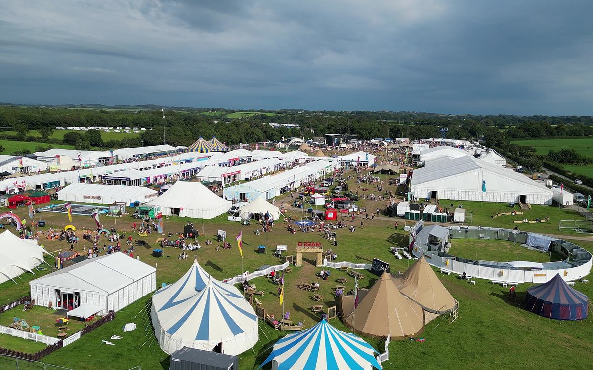 Aerial view of the 2023 National Eisteddfod of Wales showground with striped big-top tents, marquees and visitors