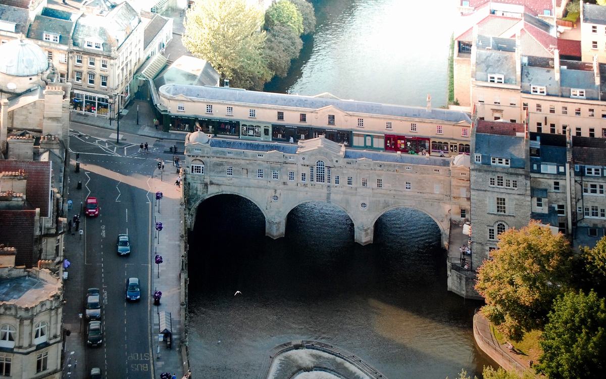 Aerial view of Pulteney Bridge spanning the River Avon in Bath, with Georgian buildings and the weir below
