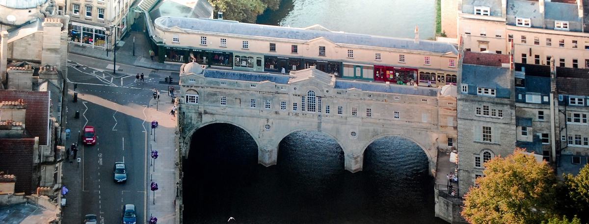 Aerial view of Pulteney Bridge spanning the River Avon in Bath, with Georgian buildings and the weir below