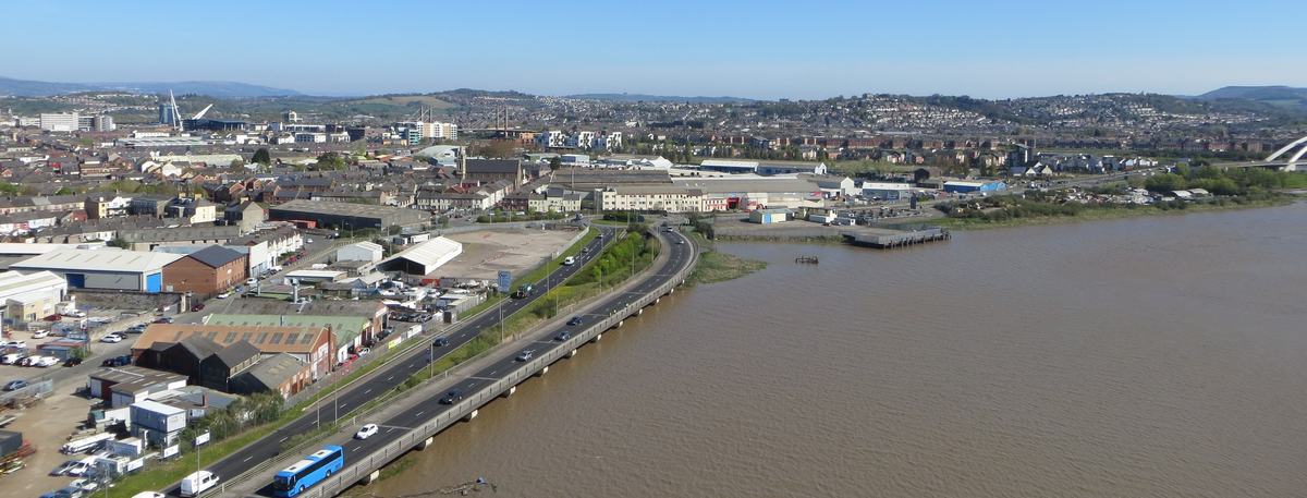 High view from Newport Transporter Bridge along the River Usk towards Newport city centre under a clear blue sky