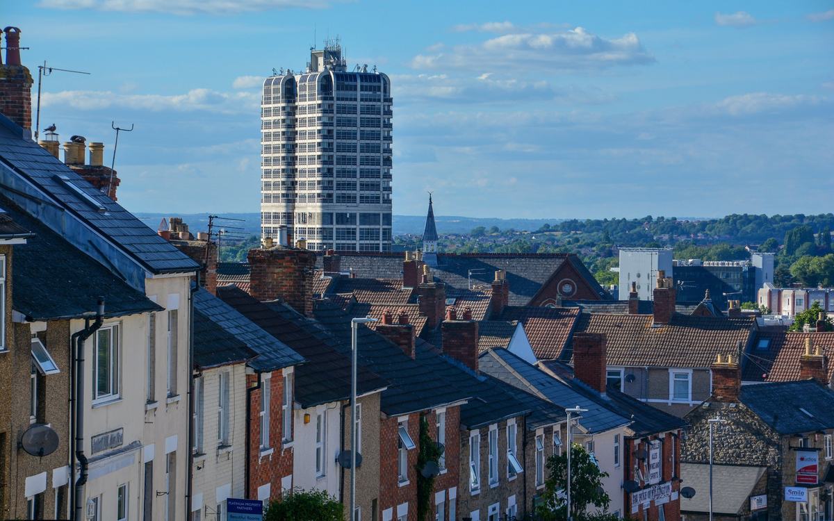 Terraced rooftops on Eastcott Hill, Swindon, looking towards the David Murray John Tower under a blue sky