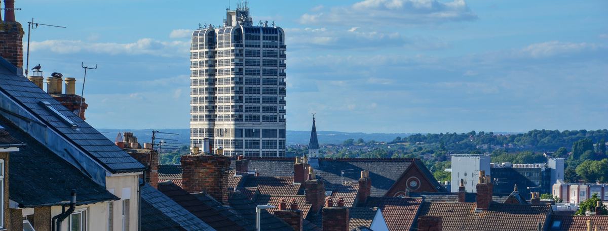 Terraced rooftops on Eastcott Hill, Swindon, looking towards the David Murray John Tower under a blue sky
