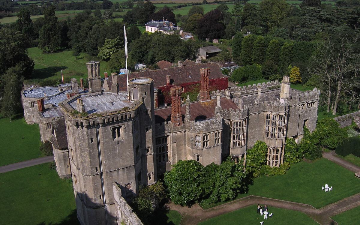 Elevated view of Thornbury Castle and its gardens, with the green Severn Vale countryside stretching beyond