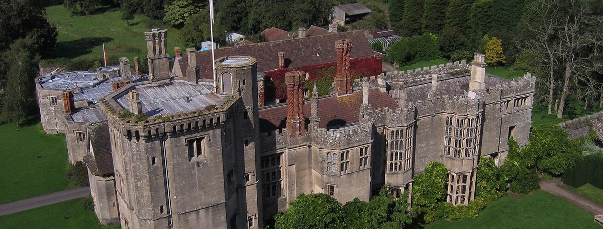 Elevated view of Thornbury Castle and its gardens, with the green Severn Vale countryside stretching beyond