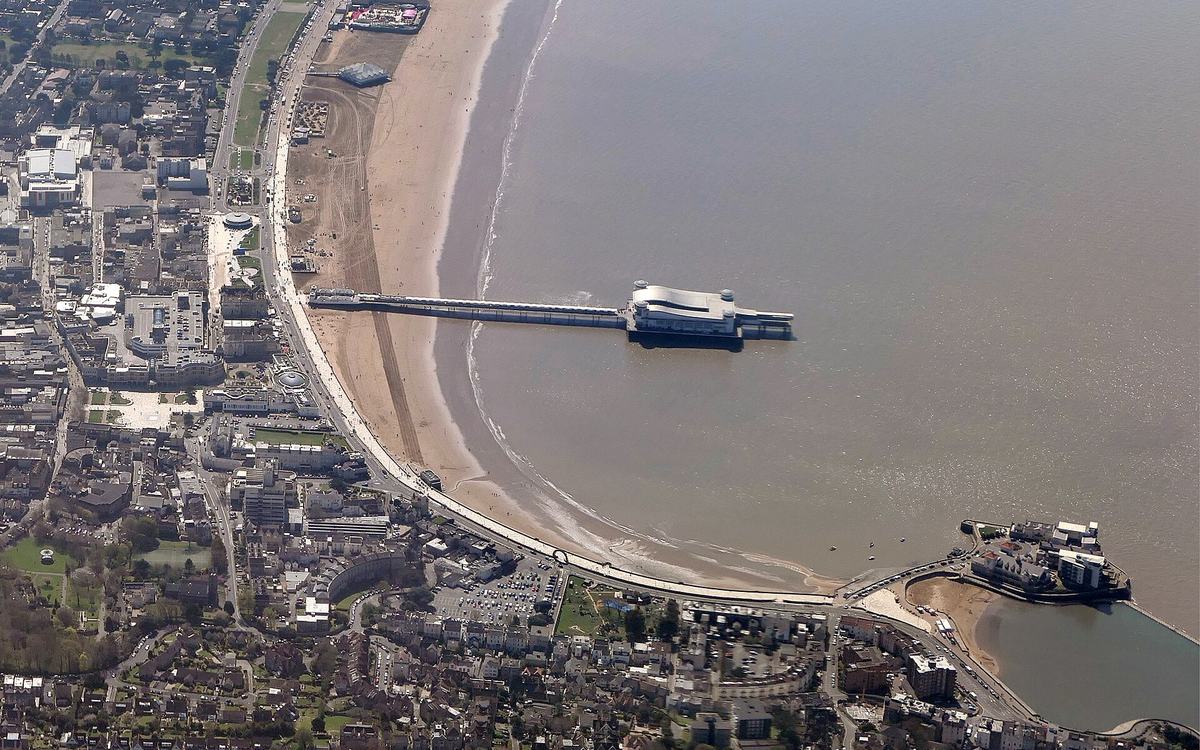 Aerial view of Weston-super-Mare seafront at low tide, with the Grand Pier, sandy beach and Knightstone Island